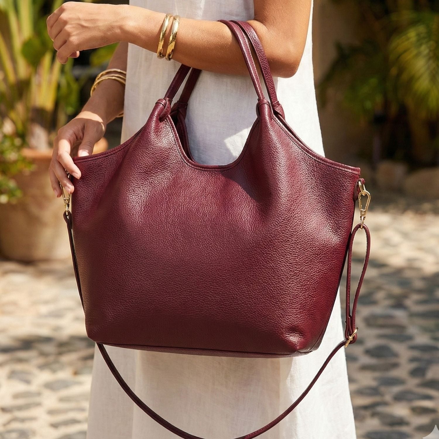 Bolso tote Vittoria de cuero genuino color burdeo aislado sobre fondo blanco para catálogo