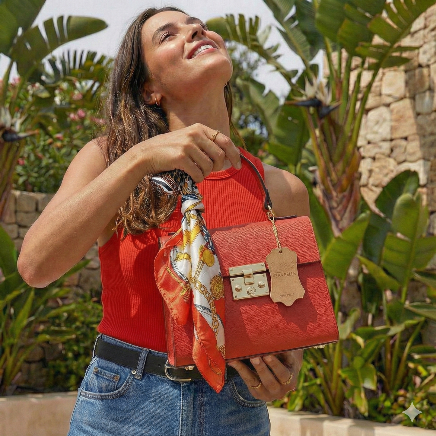 Mujer sonriendo usando bolso mini tote rojo coral de cuero italiano estilo relajado