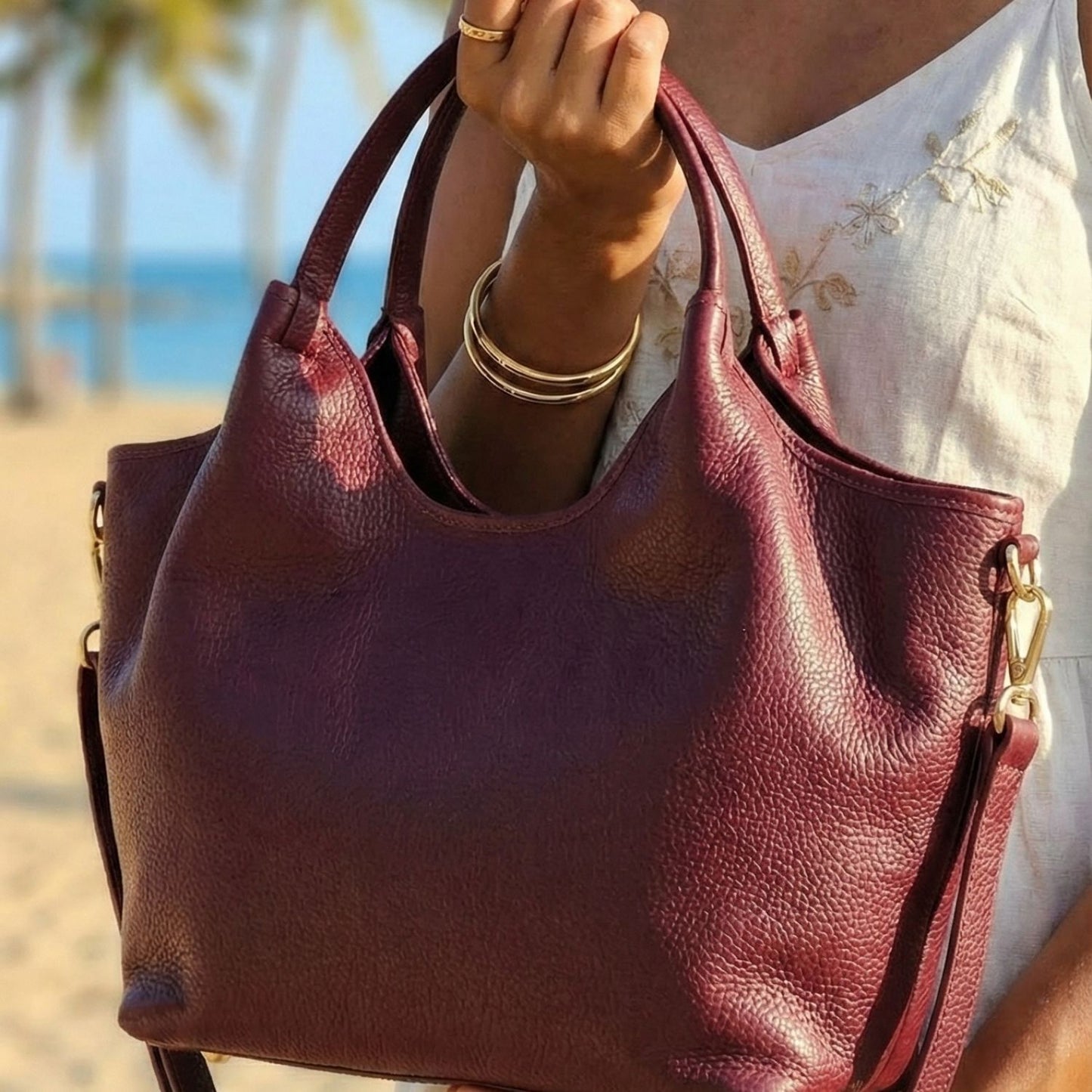 Detalle de cuero italiano color burdeo vino en bolso Tote Vittoria sostenido en el brazo - Rita Firenze